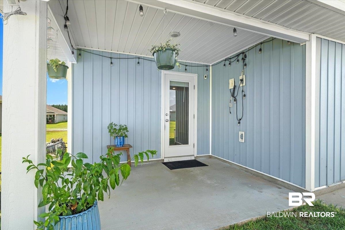 23641 Unbridled Loop Daphne, AL 36526 - Photo 30 of 40 Covered patio featuring a concrete slab and light blue vertical siding