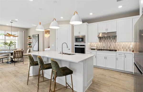 a kitchen with kitchen island a appliances dining table and chairs
