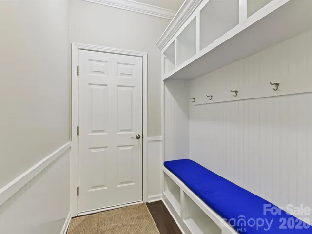 a hallway with two chairs and a book shelf