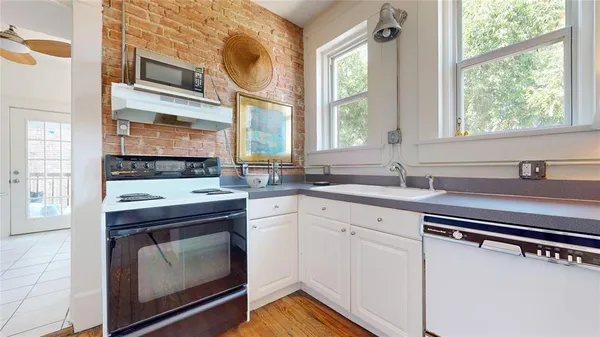 a kitchen with a sink cabinets appliances and a window