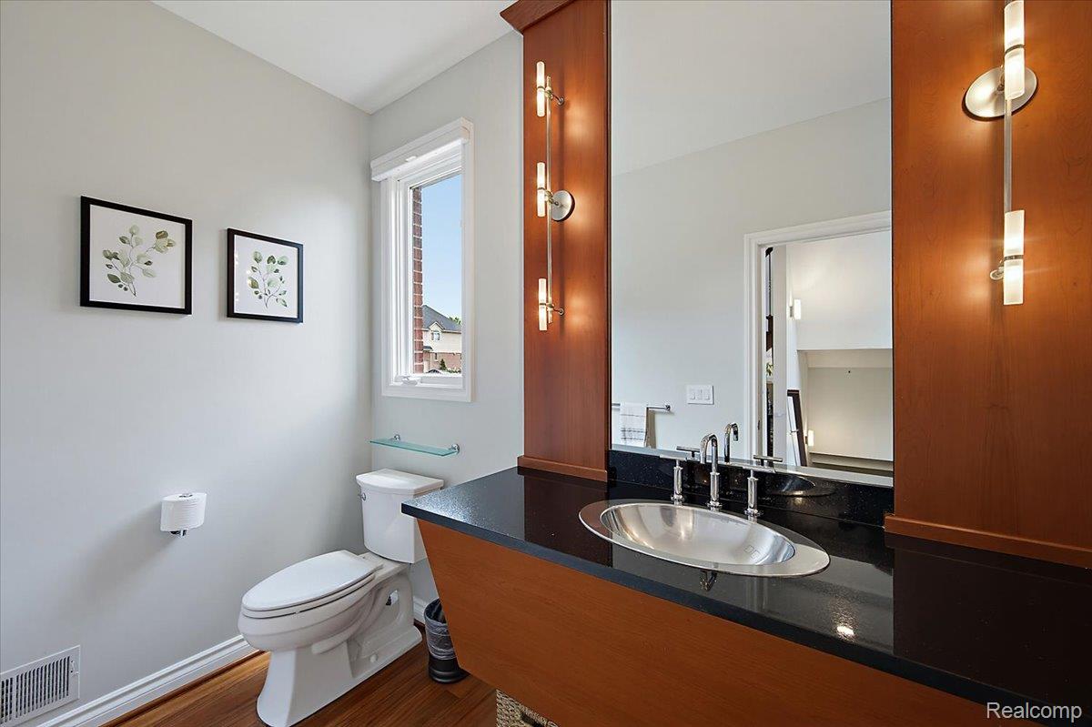 1422 Galena Rochester, MI 48306 - Photo 11 of 73 Bathroom featuring a wood-finish vanity with a black countertop and an oval undermount sink