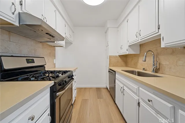 a kitchen with stainless steel appliances granite countertop a sink and a stove