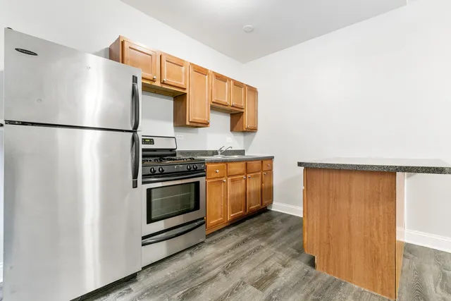 a kitchen with stainless steel appliances a refrigerator and a stove top oven