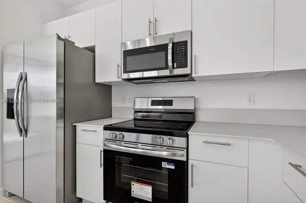 a kitchen with stainless steel appliances a stove a microwave and a refrigerator