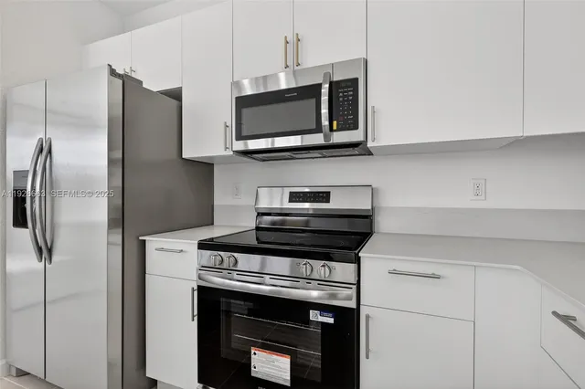 a kitchen with stainless steel appliances a stove a microwave and a refrigerator