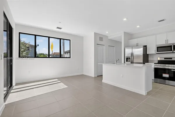 a kitchen with stainless steel appliances a refrigerator sink and microwave