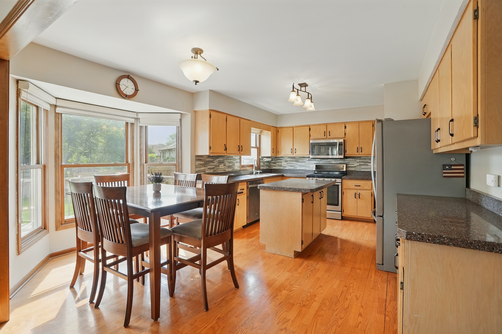 1844 Slippery Rock Road Naperville, IL 60565 - Photo 8 of 39 a kitchen with stainless steel appliances granite countertop a stove top oven a sink dishwasher a dining table and chairs with wooden floor