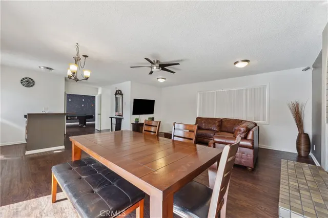 a dining room with wooden floor and a chandelier