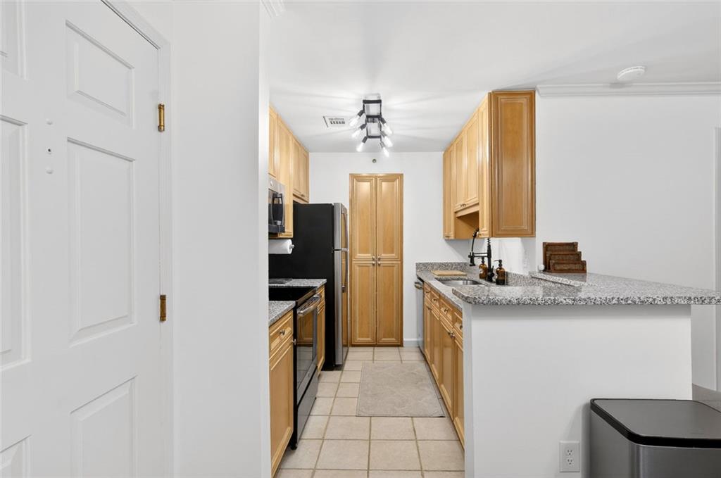 3203 Lenox Road Northeast, Unit 32 Atlanta, GA 30324 - Photo 14 of 38 a kitchen with stainless steel appliances granite countertop a sink and a refrigerator