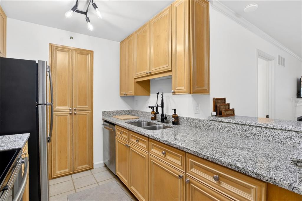 3203 Lenox Road Northeast, Unit 32 Atlanta, GA 30324 - Photo 19 of 38 a kitchen with stainless steel appliances granite countertop a refrigerator and a sink