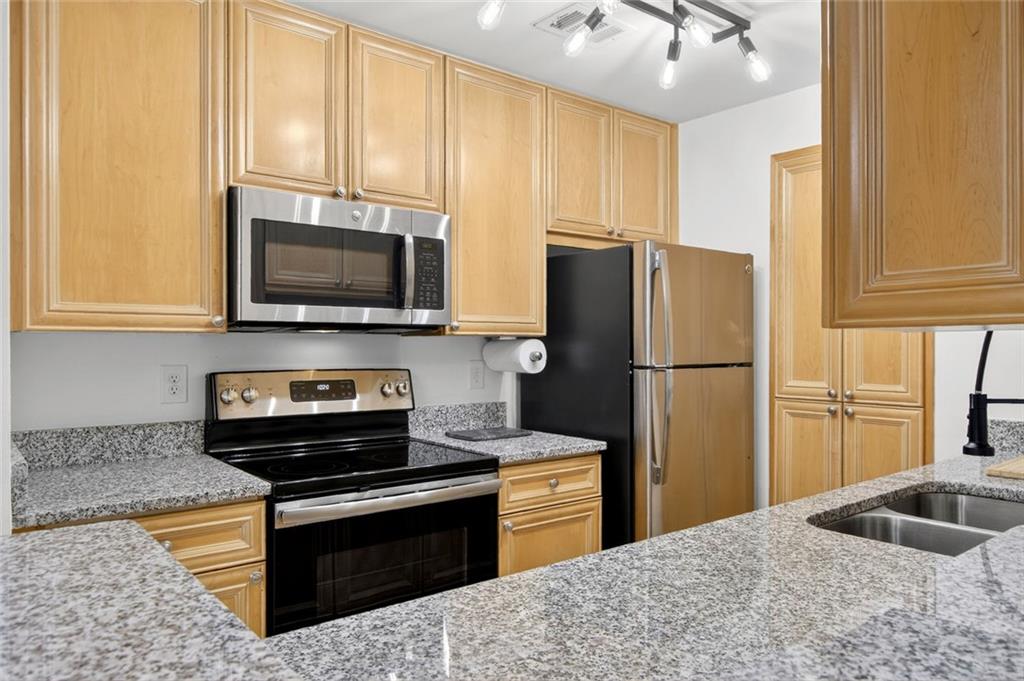 3203 Lenox Road Northeast, Unit 32 Atlanta, GA 30324 - Photo 22 of 38 a kitchen with stainless steel appliances granite countertop a refrigerator stove and microwave
