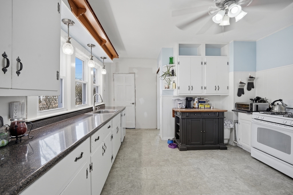 59 Woodmont Street West Springfield, MA 01089 - Photo 14 of 30 a large white kitchen with stainless steel appliances granite countertop a stove and a sink