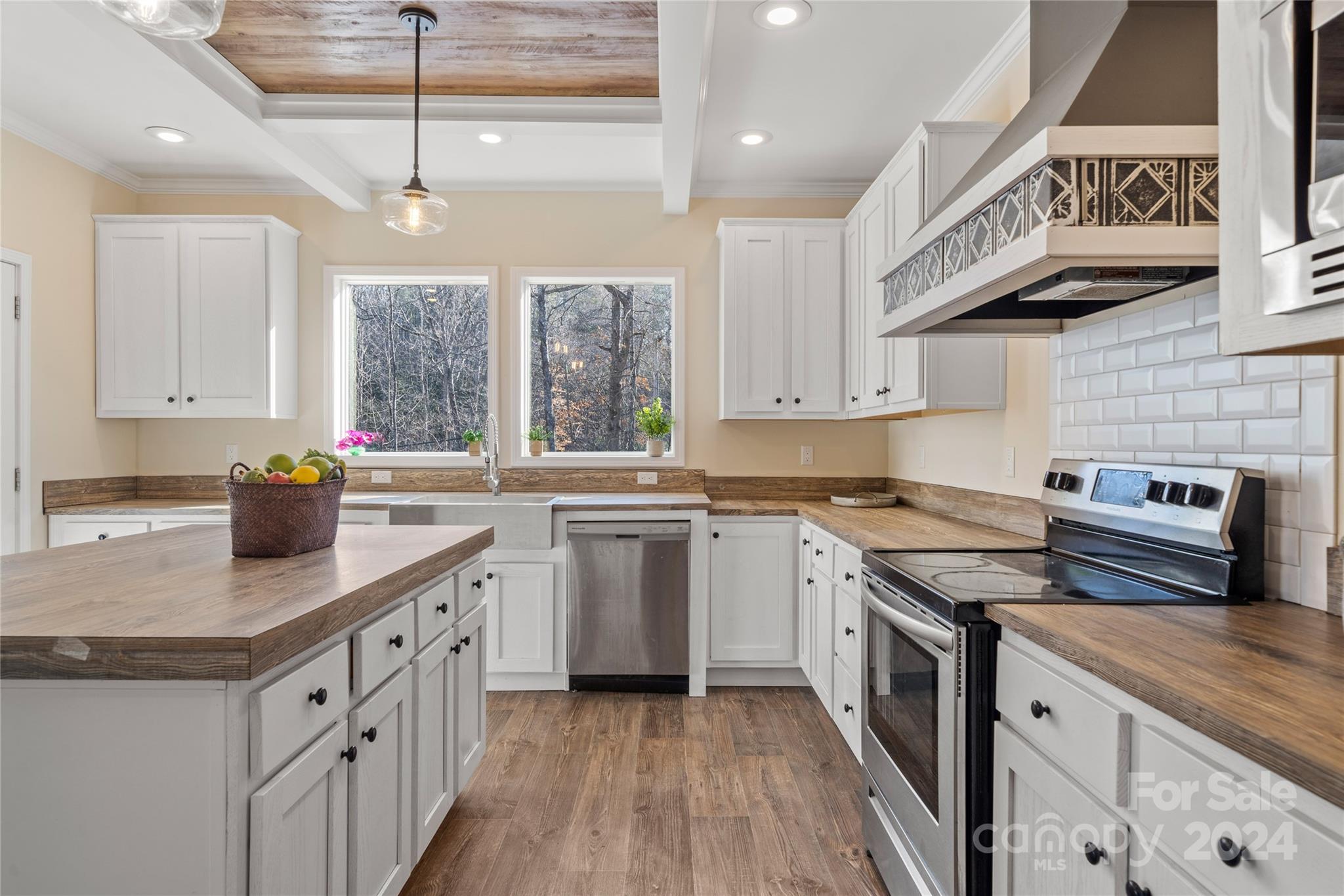 493 Patterson Road Hendersonville, NC 28739 - Photo 22 of 37 a kitchen with stainless steel appliances granite countertop a stove a sink dishwasher and white cabinets with wooden floor
