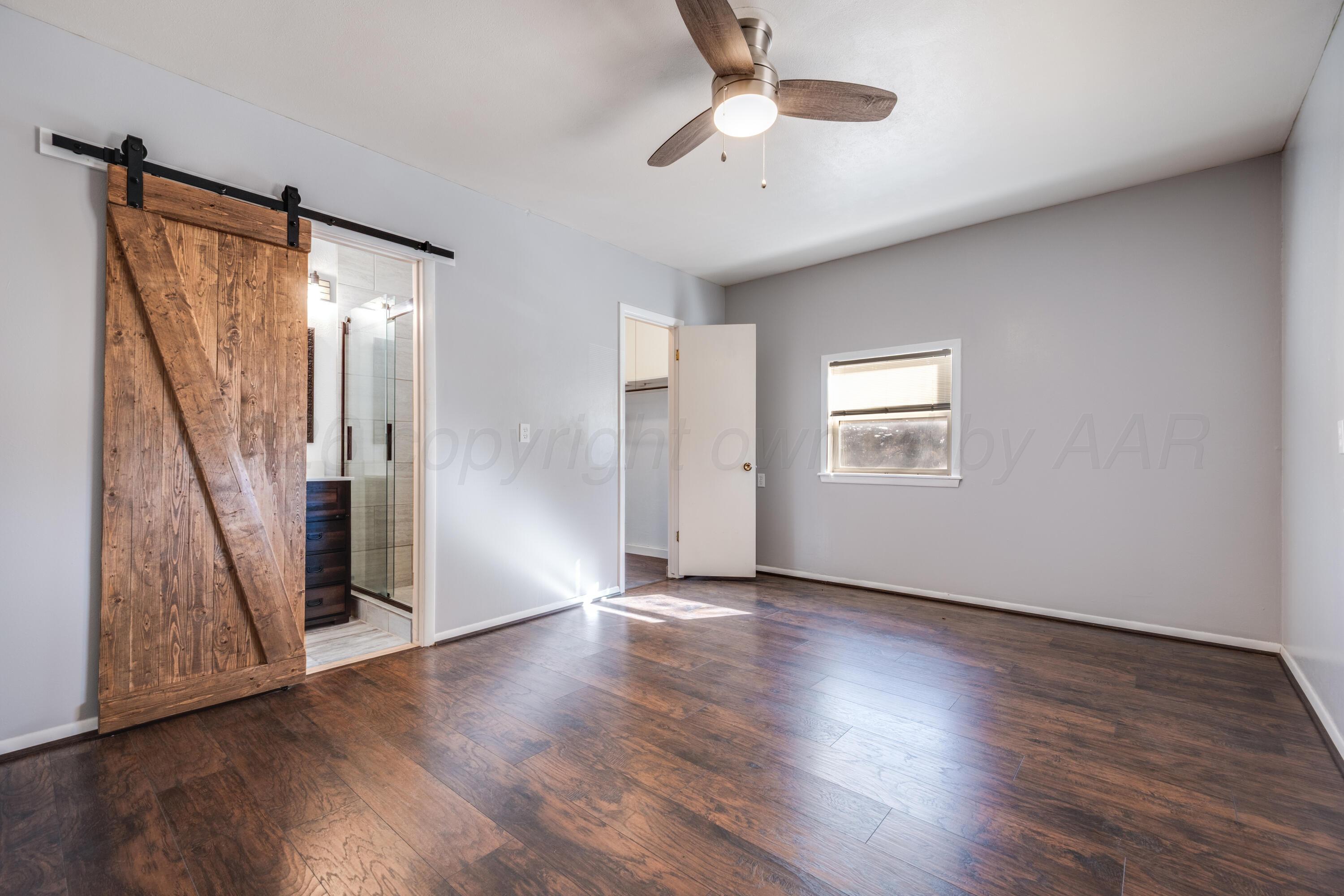 102 Lee Avenue Allison, TX 79011 - Photo 12 of 30 an empty room with wooden floor fan and windows