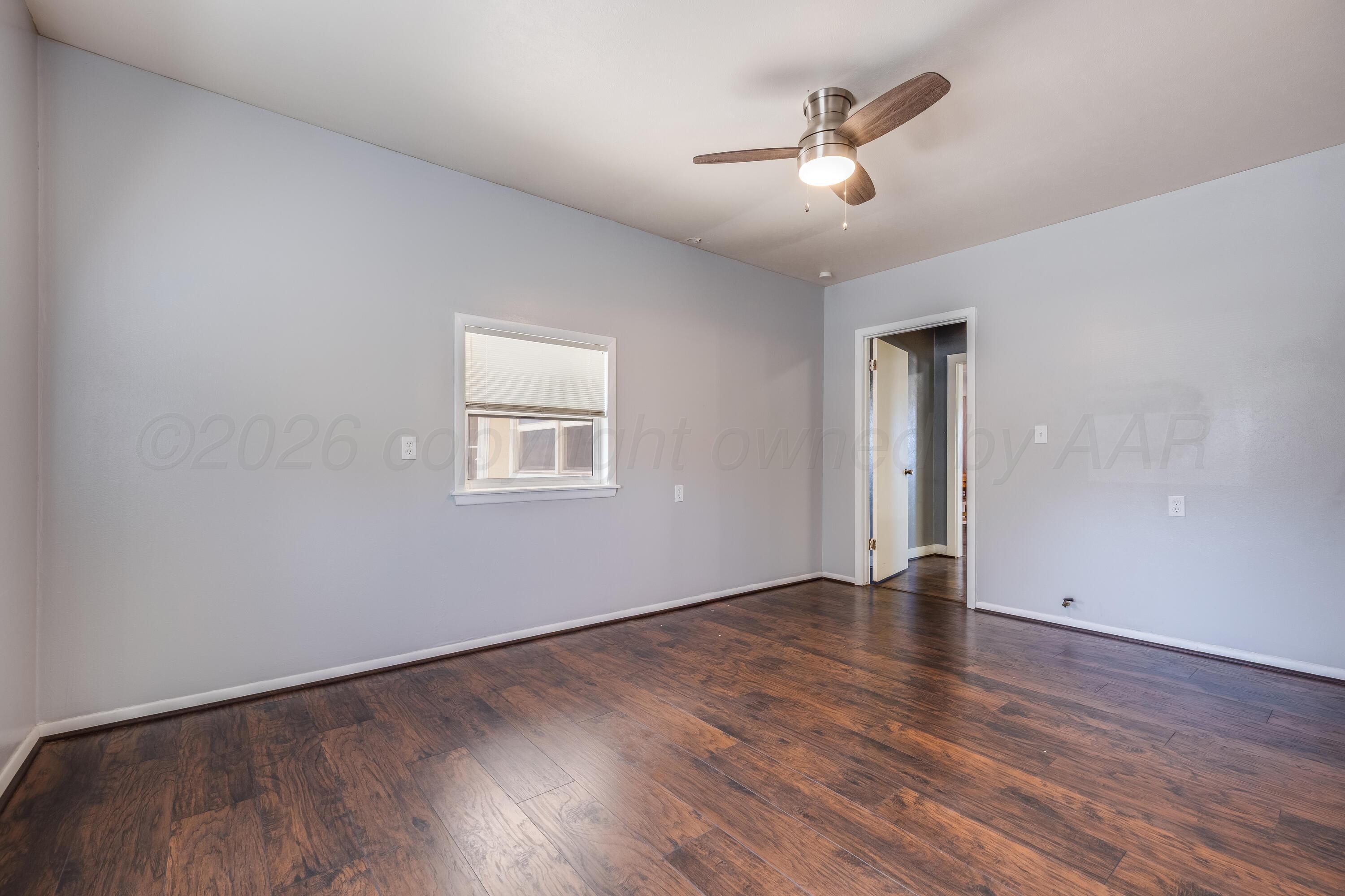 102 Lee Avenue Allison, TX 79011 - Photo 14 of 30 an empty room with wooden floor and ceiling fan