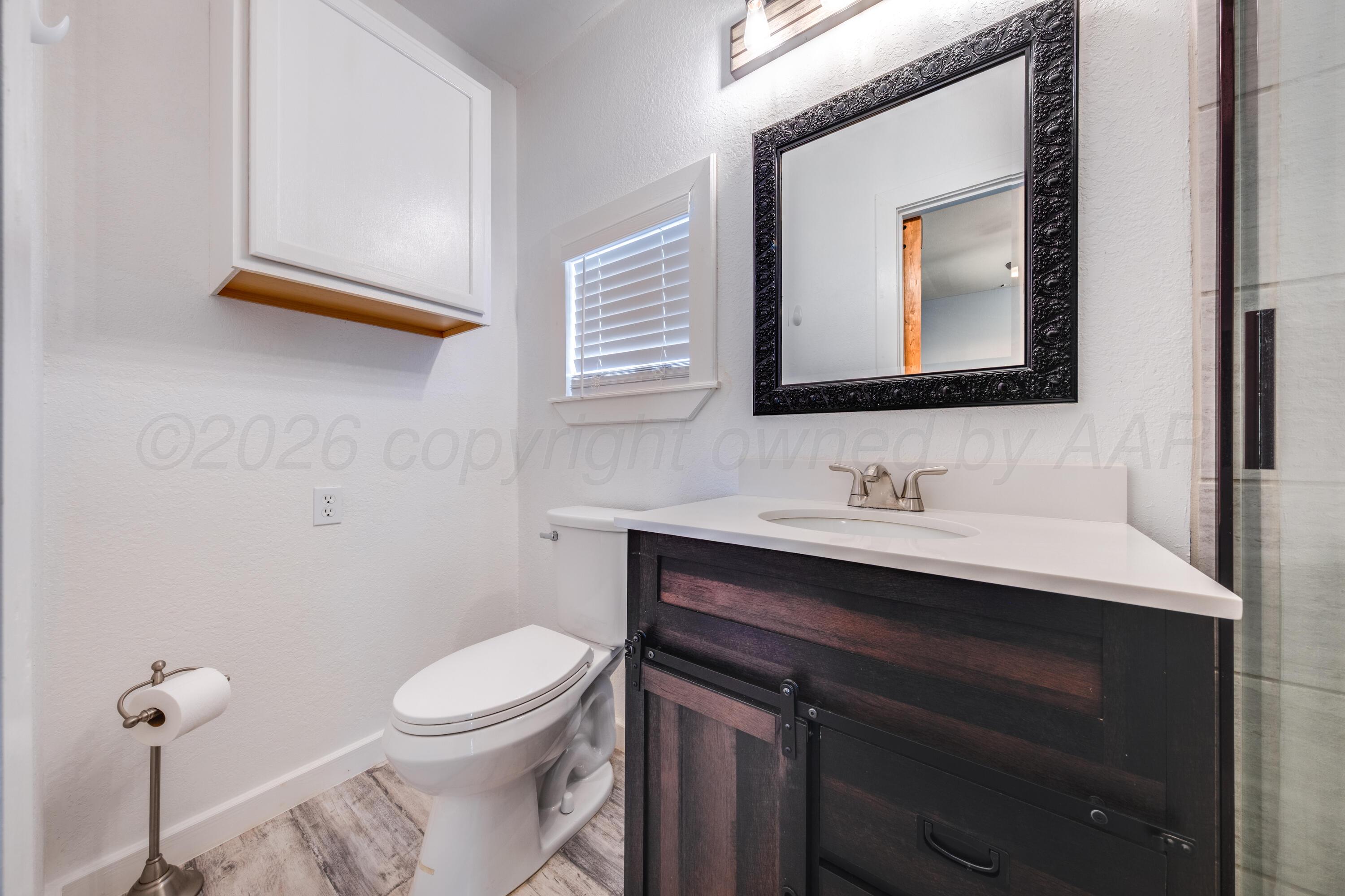 102 Lee Avenue Allison, TX 79011 - Photo 15 of 30 a bathroom with a toilet sink and mirror