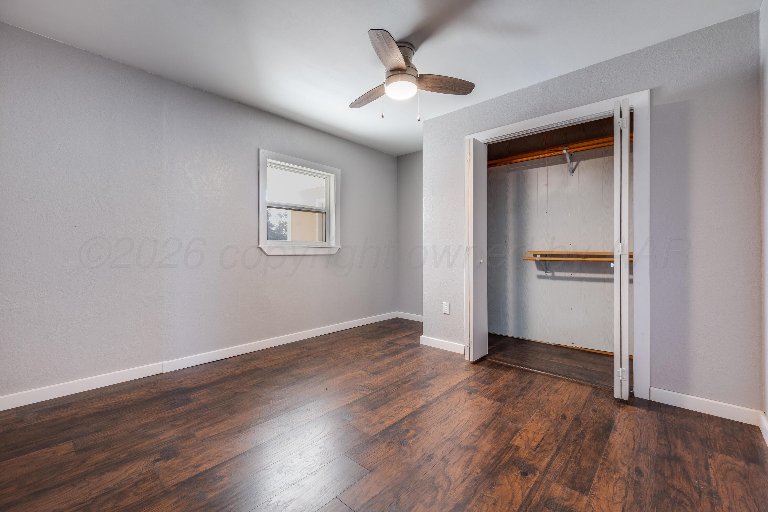 102 Lee Avenue Allison, TX 79011 - Photo 17 of 30 a view of an empty room with wooden floor and a ceiling fan