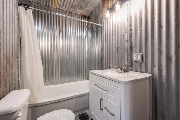 a bathroom with a sink a toilet and shower curtain
