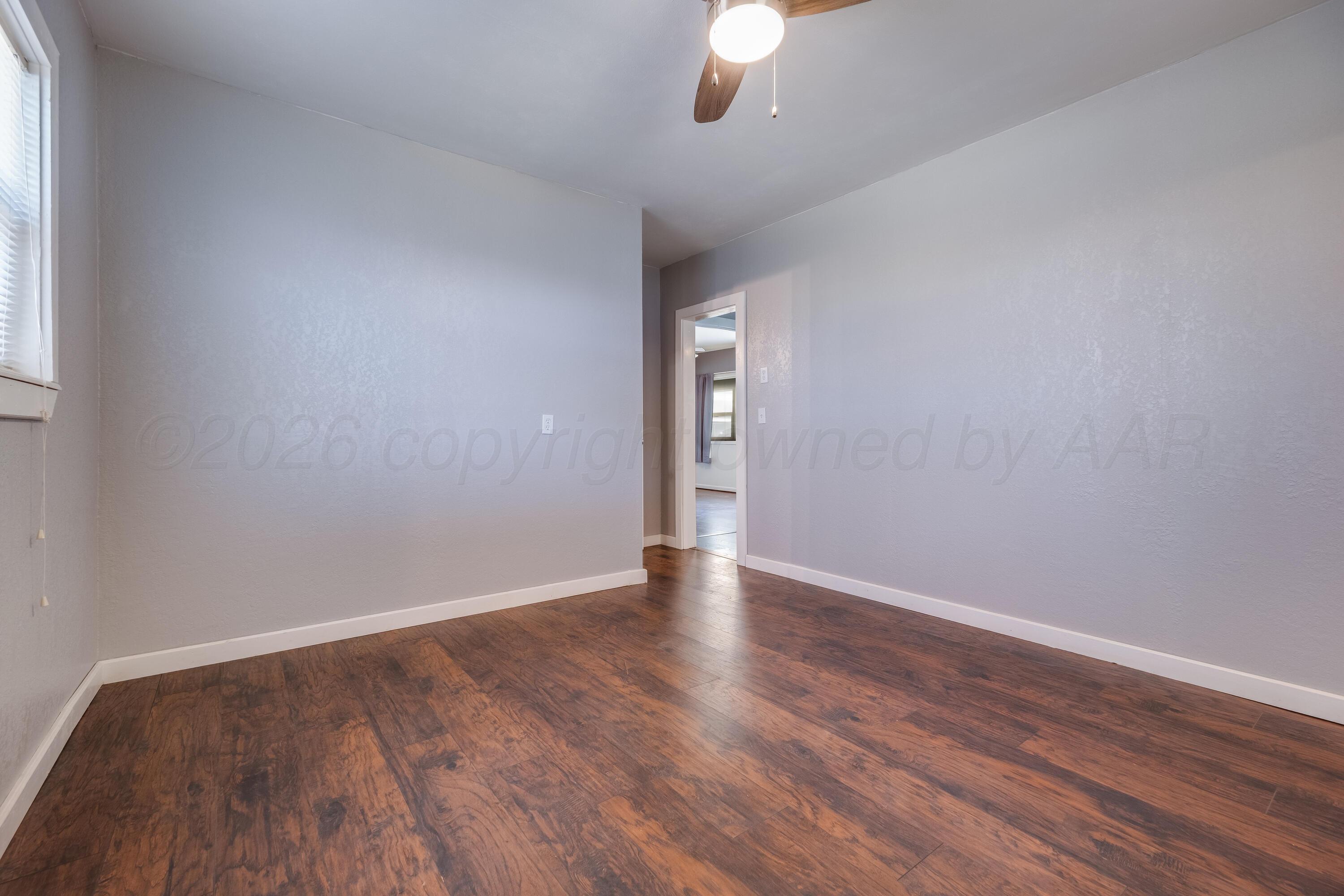102 Lee Avenue Allison, TX 79011 - Photo 22 of 30 a view of an empty room with wooden floor and a window