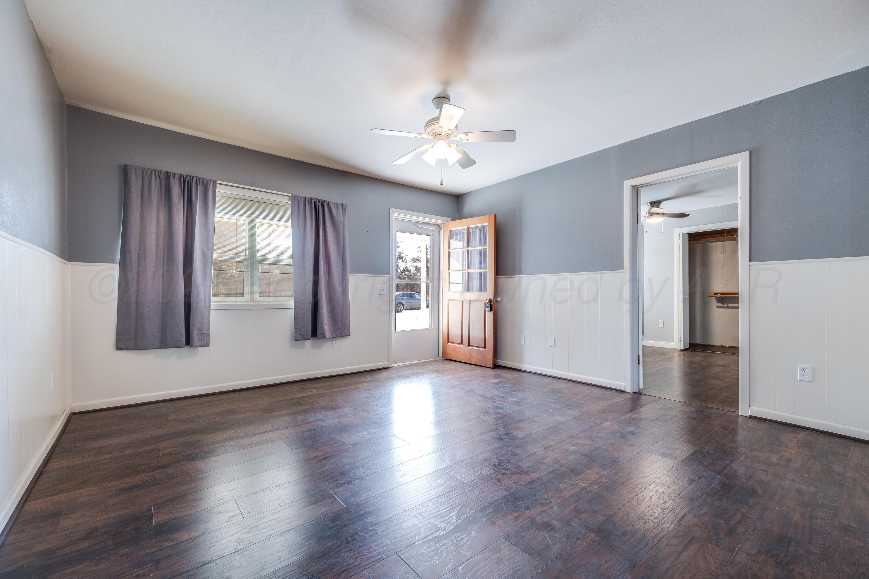 102 Lee Avenue Allison, TX 79011 - Photo 6 of 30 a view of an empty room with window and wooden floor