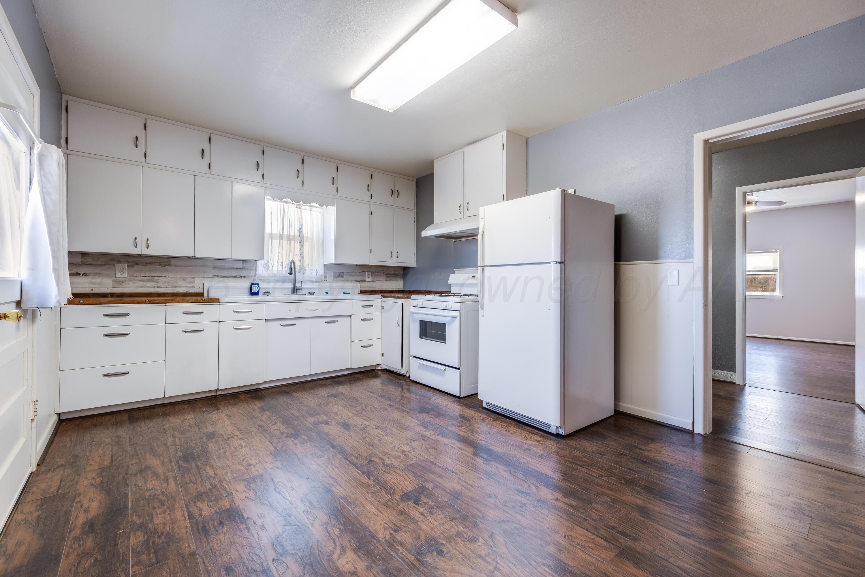 102 Lee Avenue Allison, TX 79011 - Photo 8 of 30 a kitchen with cabinets stainless steel appliances a sink and a window