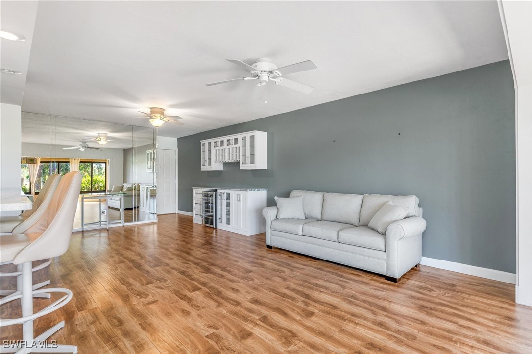 5625 Trailwinds Drive, Unit 412 Fort Myers, FL 33907 - Photo 14 of 40 a living room with furniture and a wooden floor