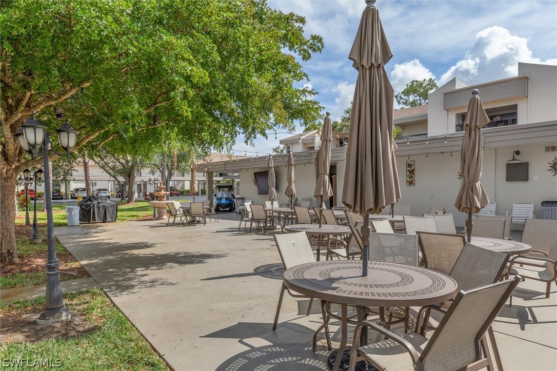 5625 Trailwinds Drive, Unit 412 Fort Myers, FL 33907 - Photo 38 of 40 a view of a patio with a dining table and chairs with wooden fence