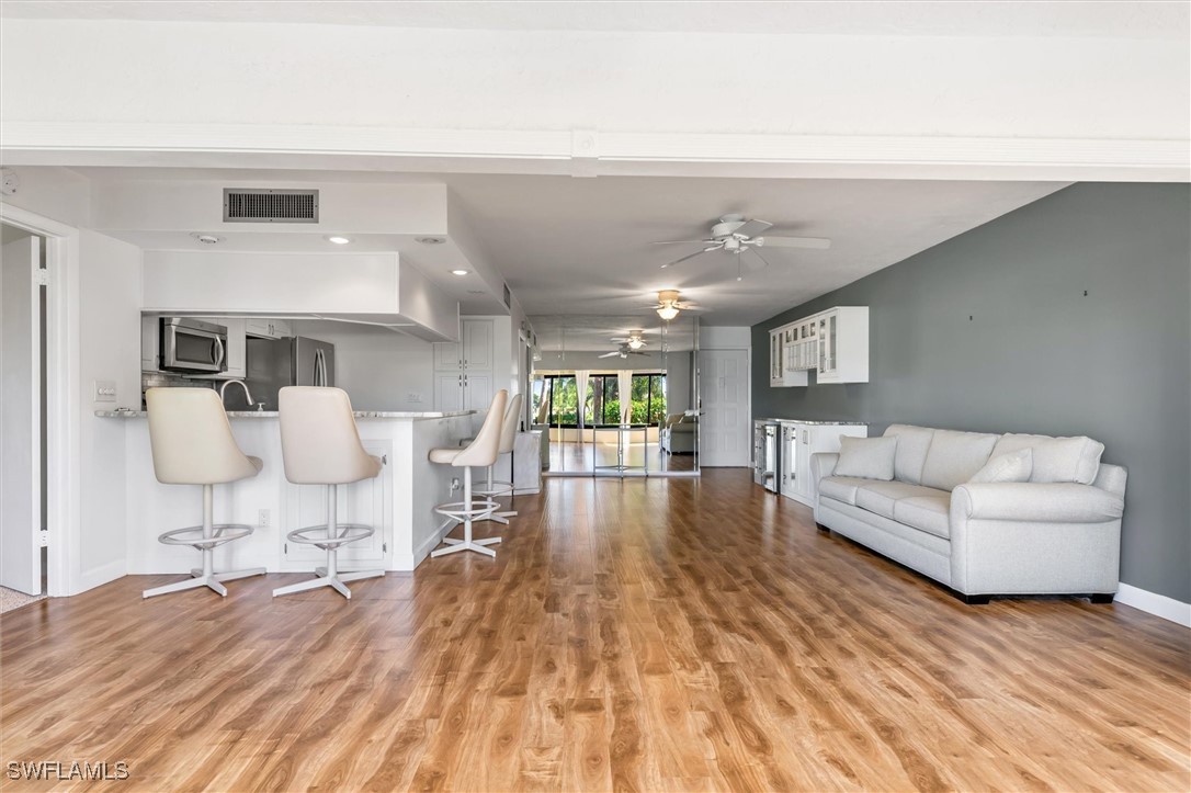 5625 Trailwinds Drive, Unit 412 Fort Myers, FL 33907 - Photo 7 of 40 a living room with furniture and a wooden floor