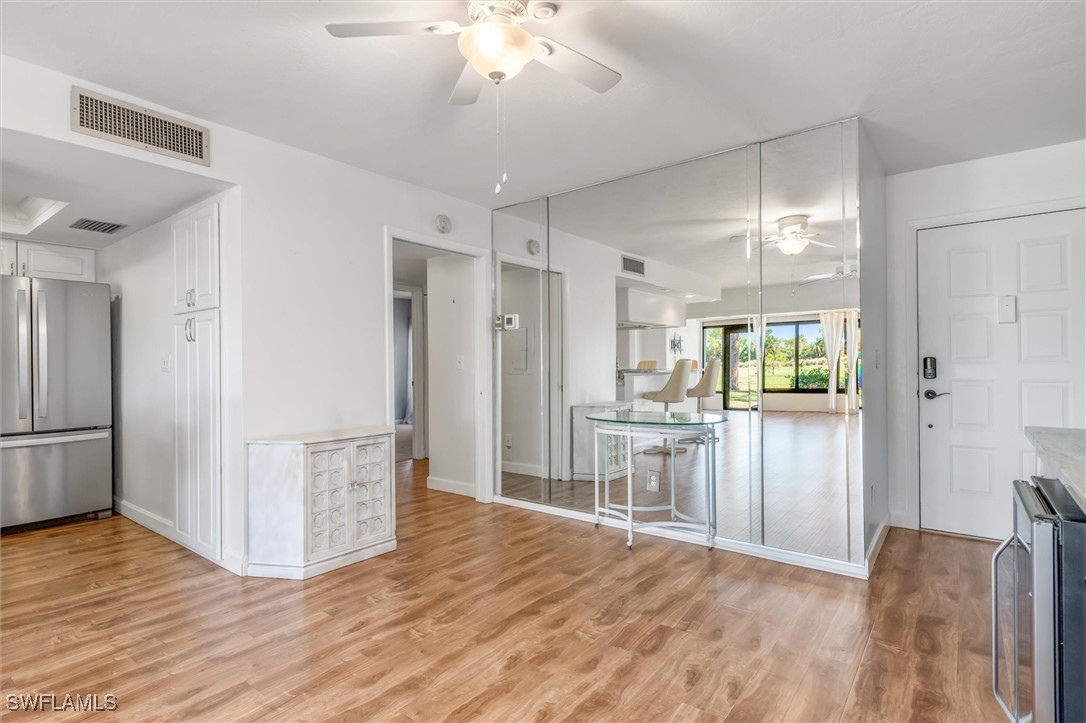 5625 Trailwinds Drive, Unit 412 Fort Myers, FL 33907 - Photo 9 of 40 a view of kitchen with refrigerator stove and wooden floor