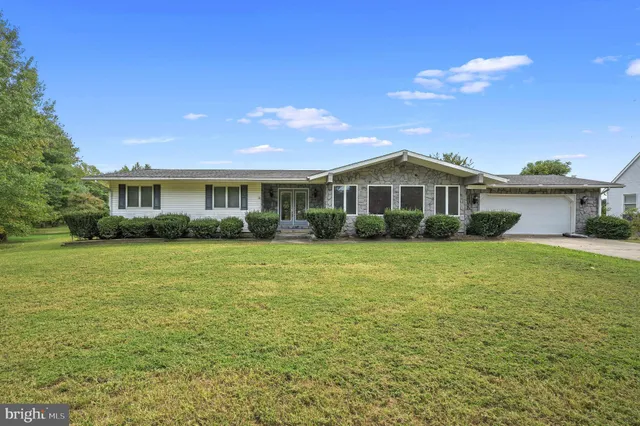 a view of a house with a yard and potted plants