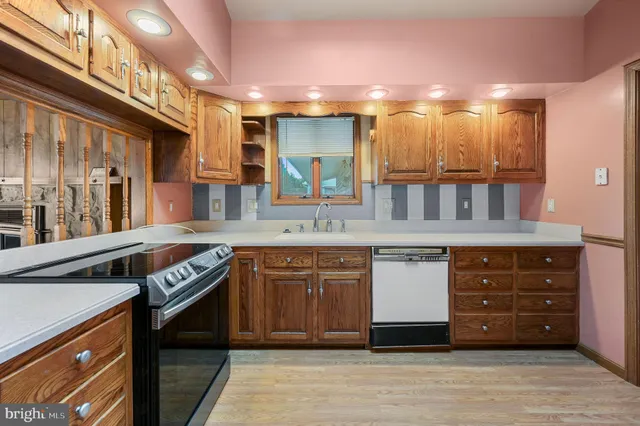 a kitchen with stainless steel appliances granite countertop a stove cabinets and wooden floor