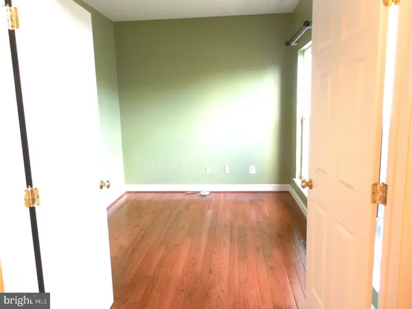 a view of a room with wooden floor and a window