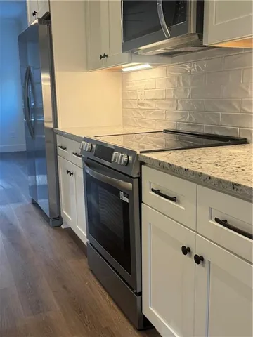 a kitchen with granite countertop cabinets stainless steel appliances and a counter space