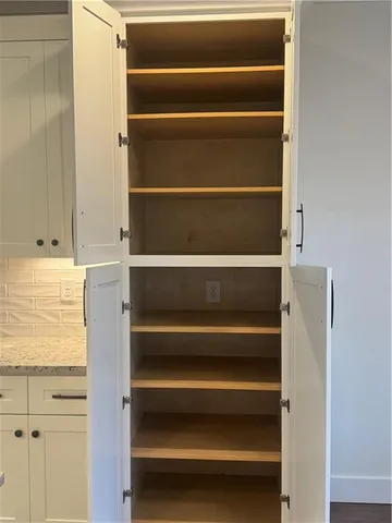 a view of walk in closet with empty racks