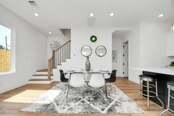 a dining room with wooden floor and a chandelier