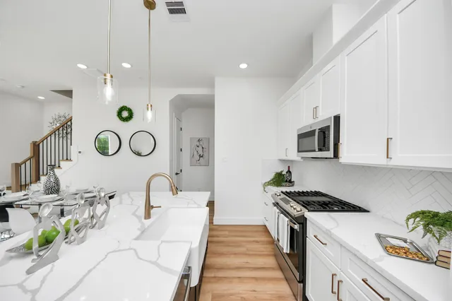 a kitchen with white cabinets and black appliances
