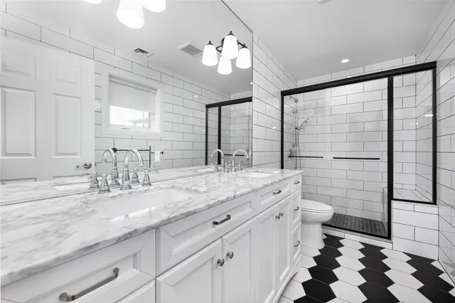a bathroom with a granite countertop sink mirror and toilet