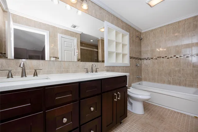 a bathroom with a double vanity sink toilet mirror and bathtub