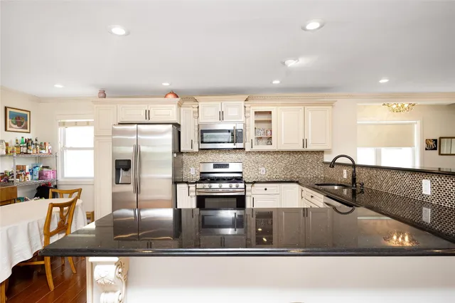a kitchen with stainless steel appliances granite countertop a sink refrigerator and cabinets
