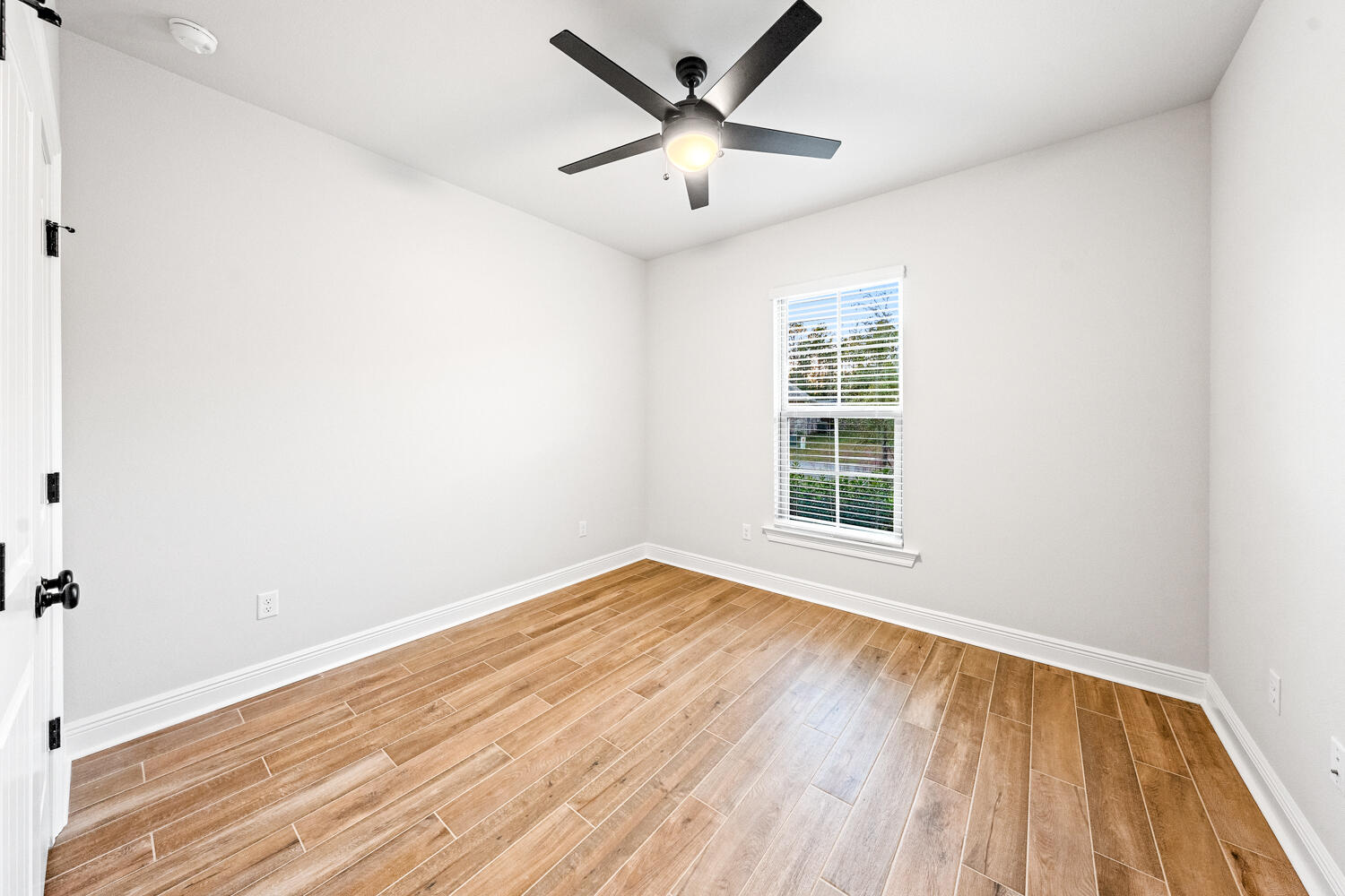 232 West Tweet Street Freeport, FL 32439 - Photo 16 of 23 an empty room with wooden floor and windows