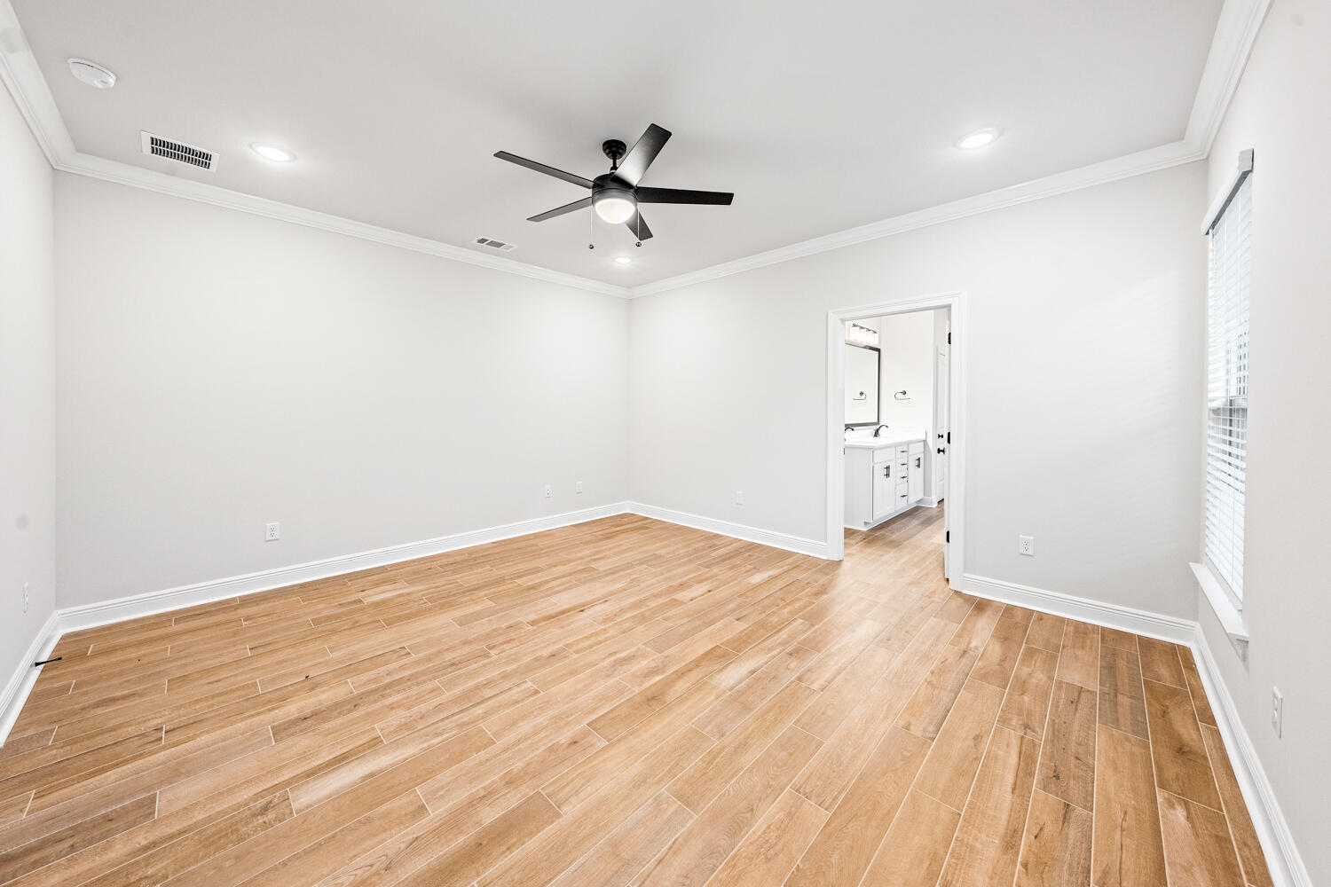 232 West Tweet Street Freeport, FL 32439 - Photo 10 of 23 an empty room with wooden floor a ceiling fan and kitchen view