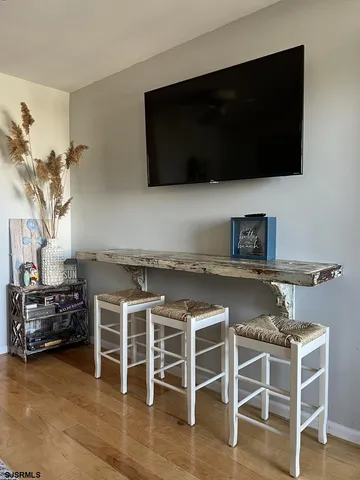 a living room with a flat screen tv a rug and a stove