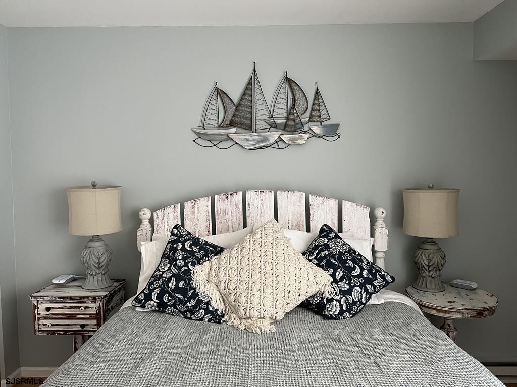 330 42nd Street South, Unit B15 Brigantine, NJ 08203 - Photo 14 of 21 a bedroom with a bed and a lamp on table