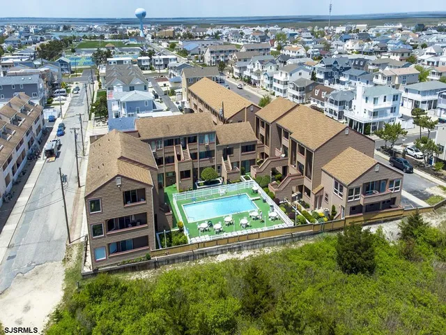 an aerial view of residential houses with outdoor space and parking