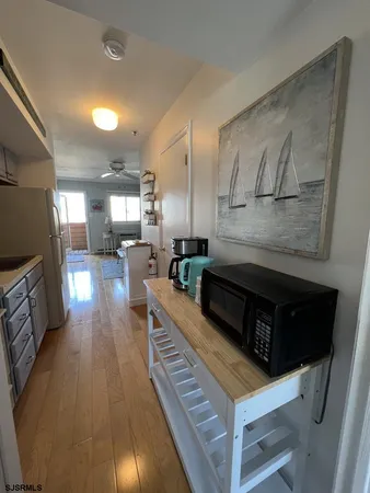 a living room with stainless steel appliances kitchen island granite countertop furniture and a wooden floor
