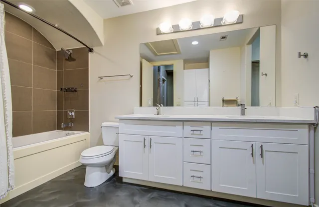 a bathroom with a double vanity sink a toilet a mirror and shower