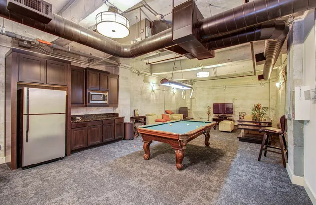 a room with chairs and stainless steel appliances