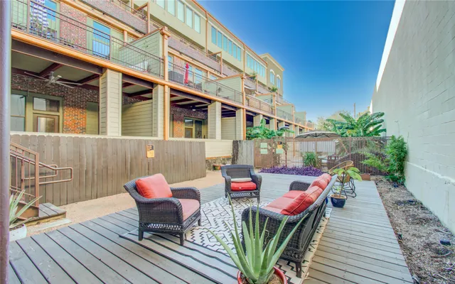 a balcony with wooden furniture and potted plants