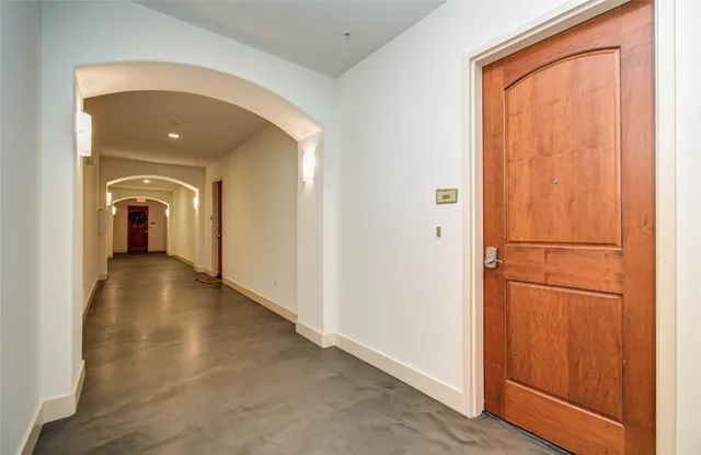 a view of a hallway with wooden floor and closet