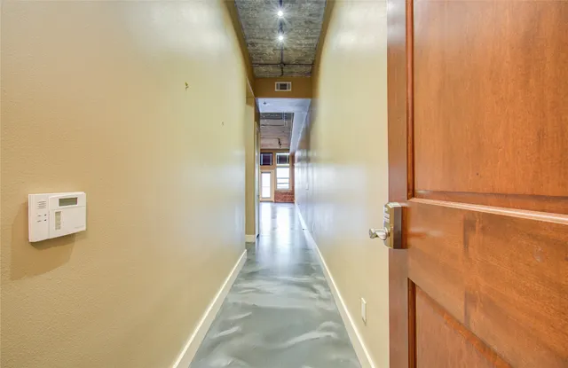 a view of a hallway with wooden floor